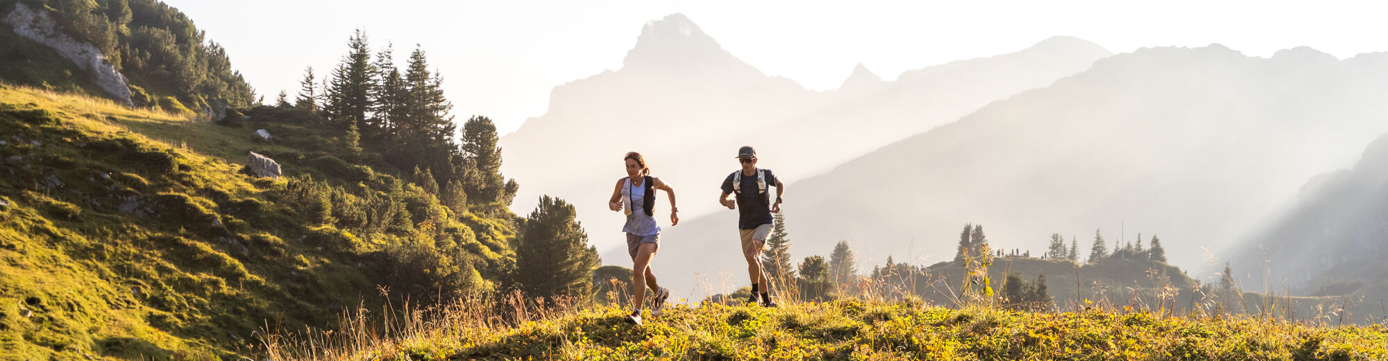 Zwei Trailrunner laufen durch die Berglandschaft von Lech 